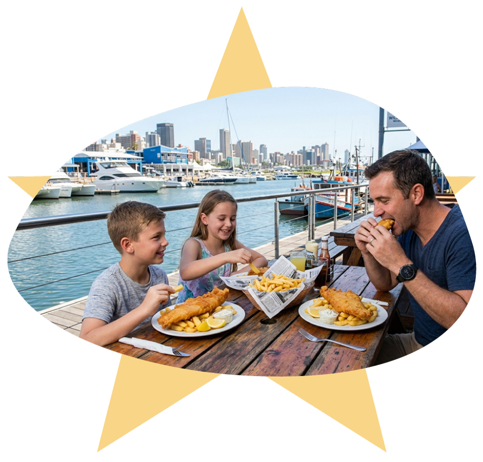 Family enjoying a meal of battered hake and chips at an outdoor table at The Starfish fish and chips shop, located at Wilson's Wharf harbor front in Durban.